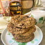 A stack of Spelt Chocolate Chip Cookies piled six high with a glass of milk