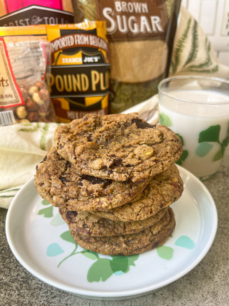 A stack of Spelt Chocolate Chip Cookies piled six high with a glass of milk