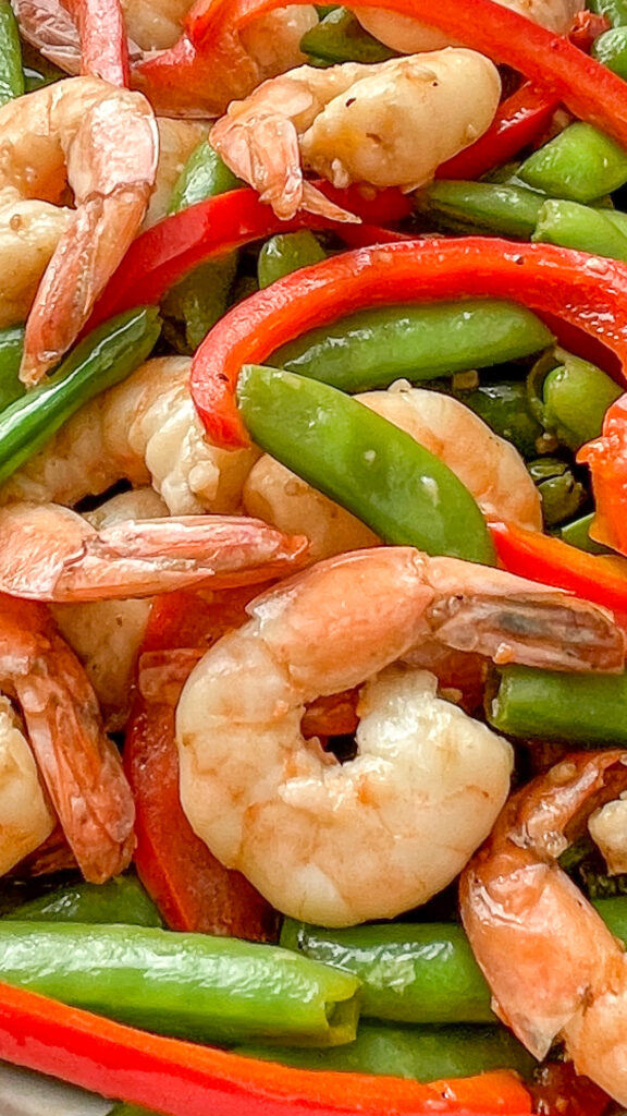 CLOSEUP of shrimp, stirfried with red peppers and snap peas