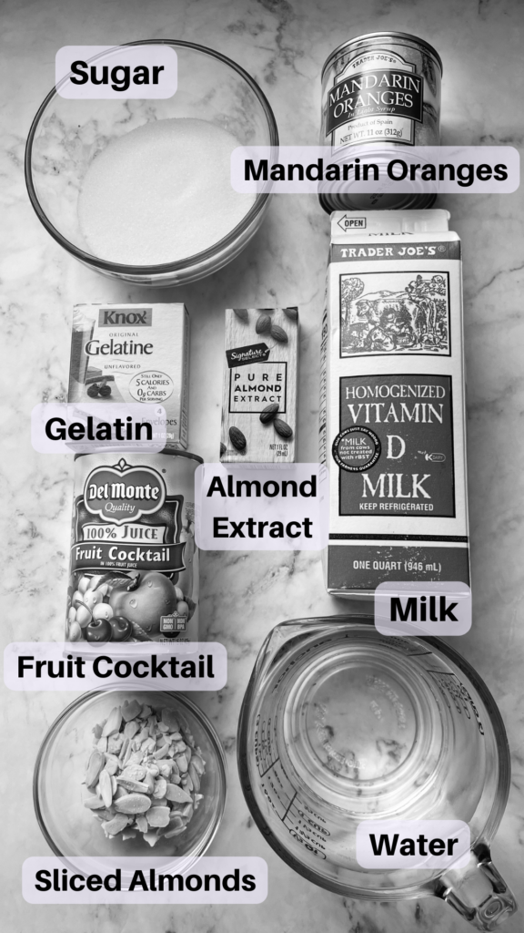 Black and White photo showing all ingredients needed for the recipe. From top left to bottom right, sugar, milk, gelatin, almond extract, fruit cocktail, mandarin oranges, and water.