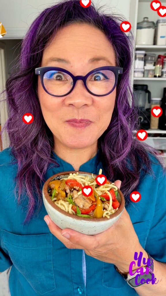 Photo of Carole with her purple hair with a bowl of Lo Mein Noodles and social media hearts decorating the page.